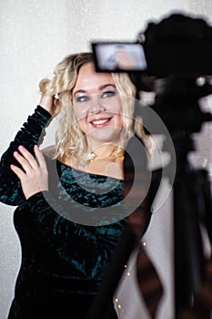 Behind the scenes of professional studio shooting. Model posing for the camera. Photo of blonde on camera display