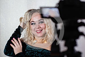 Behind the scenes of professional studio shooting. Model posing for the camera. Photo of blonde on camera display