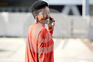 Behind of smiling African american woman talking on cellphone outdoors