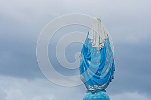 Behind view of The Blessed Virgin Mary statue standing in front of The Roman Catholic Diocese.