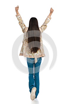 behind view of casual young woman with long hair holding arms up