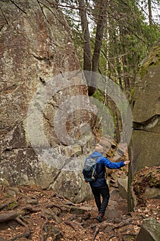 Behind view of tourist passing between pair of rocks