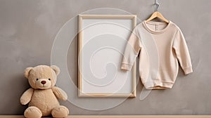 Beige baby sweatshirt on hanger, blank picture frame mockup and plush toy bear