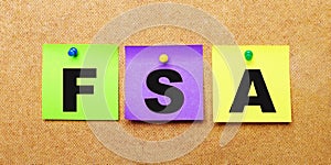 On a beige background, multi-colored stickers for notes with the word FSA Flexible Spending Account