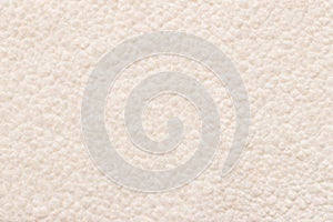 Beige background wool texture, sheep fluffy warm fur. Carpet of artificial factory fabric material, fake wool lumps