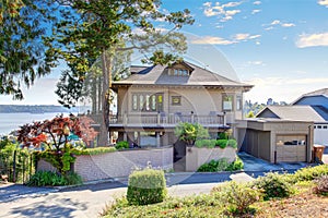 Beige brick house with tile roof and beautiful curb appeal.