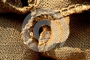 Beige brown color textured burlap textile material with seam. macto view.