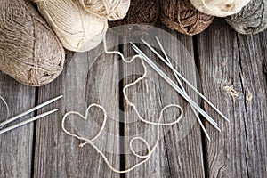 Beige, brown, gray and white balls of yarn. Wooden background