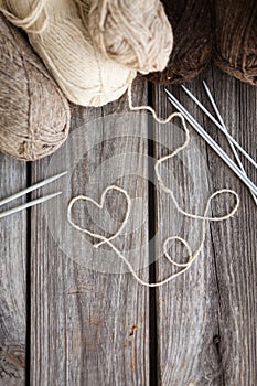 Beige, brown, gray and white balls of yarn. Wooden background