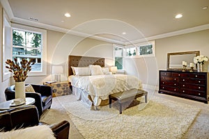 Beige and brown master bedroom boasts tufted queen bed