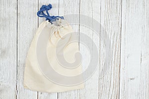 Beige canvas bag on weathered whitewash textured wood background