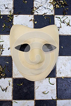 beige carnival mask on chequered background