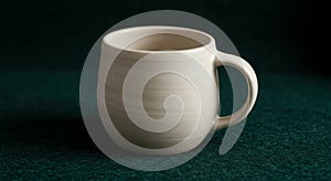 Beige ceramic mug with a rounded body and smooth texture, featuring a sturdy handle