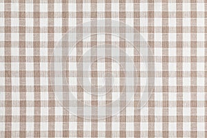 Beige checkered fabric. Tablecloth texture photo