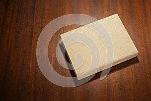 Beige color book on the wooden scratched table.