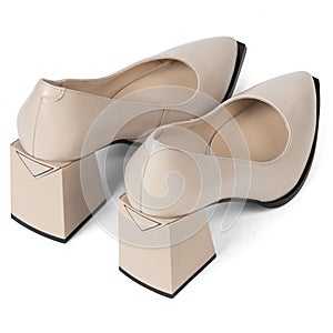 Beige comfortable office women's shoes with black sole with thick heels and a sharp nose on a white background