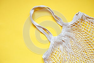 Beige cotton string knitted bag on yellow background