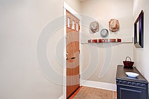 Beige entryway with cabinet, mirror ,hats hanging on the wall