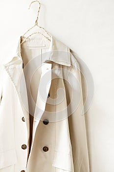 Beige or greige elegant trench coat over white