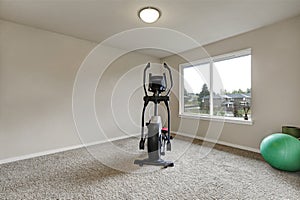 Beige interior of small home gym with sport equipment