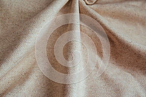 Beige linen fabric for drapery. A piece of cotton with purple folds