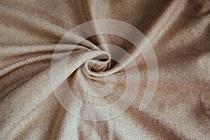 Beige linen fabric for drapery. A piece of cotton with purple folds