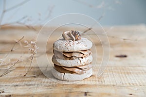 Beige macaroon cookie on wooden background