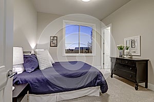 Beige and pale gray bedroom design accented with blue bed