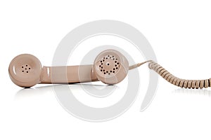 Beige phone receiver on a white background