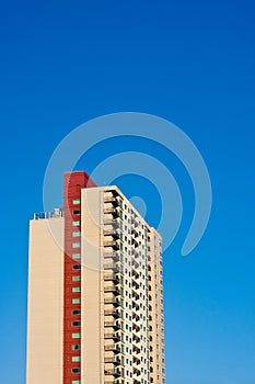 Beige and Red Condo Tower Rising into Blue Sky