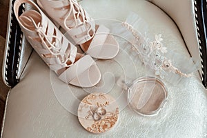 Beige shoes for the bride, wedding rings, perfume, garter.