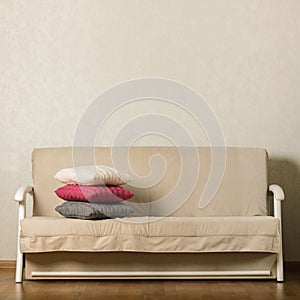 Beige sofa with colorful pillows pink, grey, white in the livi