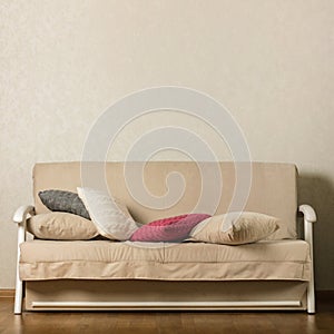 Beige sofa with colorful pillows pink, grey, white in the livi