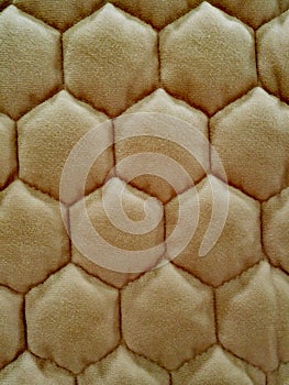 Beige soft background. Upholstering as bee honeycombs.