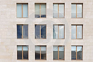 Beige stone wall with many windows