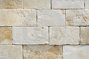 Beige stone wall with textured surface pattern. AI generative