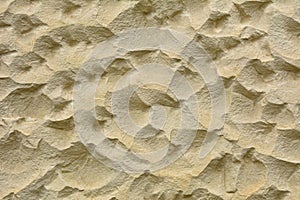 Beige stone wall with wavy surface