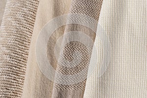 Beige, taupe, light brown, creamy wool, cotton and cashmere blend knitted sweaters texture stack together. Warm neutral color