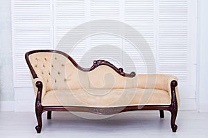 Beige textile classical style sofa in vintage room.