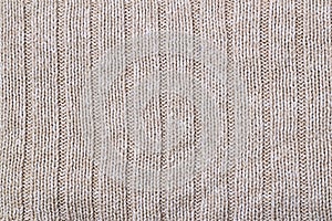 Beige texture of knitted wool sweater. Hand knitting. Knit and purl stitch pattern
