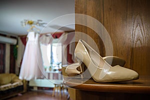 Beige wedding shoes in bride`s room close