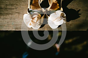 Beige wedding shoes on a wooden windowsill