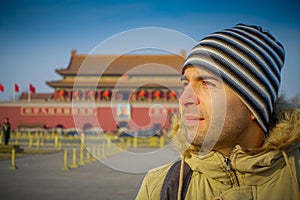 BEIJING, CHINA - 29 JANUARY, 2017: Hispanic tourist on Tianmen square looking around, famous forbidden city building in