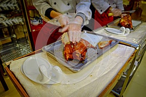 BEIJING, CHINA - 29 JANUARY, 2017: Professional chef cutting a famous traditional peking duck using knife, delicious