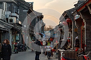 BEIJING, CHINA - DEC 24, 2017: Tourists and locals walking on hutong traditional street of Beijing