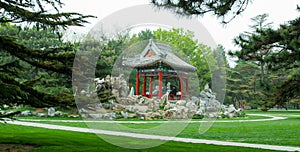 The landscape of Temple of Heaven Park. A pointed-roof pavilion where people can rest inside.