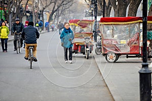 BEIJING, CHINA - MARCH 12, 2016: Tourists in a rickshaw in a hut
