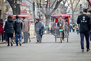 BEIJING, CHINA - MARCH 12, 2016: Tourists in a rickshaw in a hut