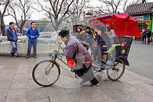 BEIJING, CHINA - MARCH 12, 2016: Tourists in a rickshaw in a hut