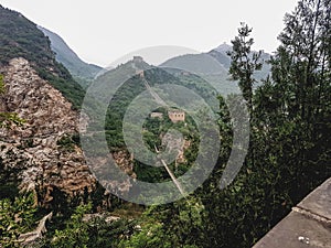 Beijing - A panoramic view on the old part of Great Wall Jinshanling in China. The wall is spreading on tops of mountains